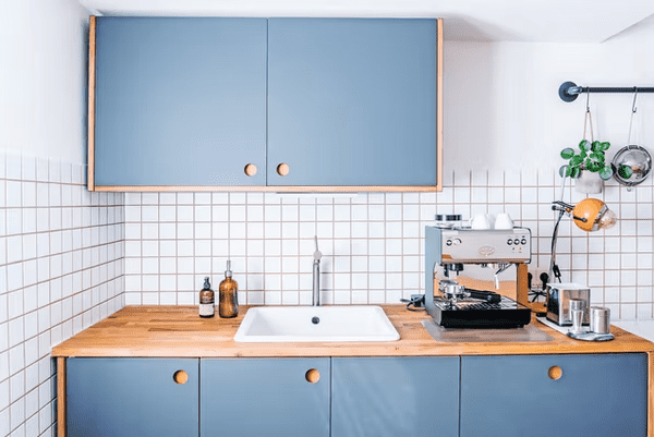 A kitchen with blue-colored furnitures.