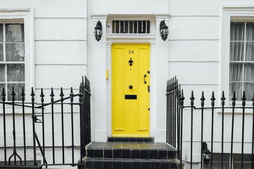 Yellow door gives a welcoming feeling, according to Feng Shui color meaning.